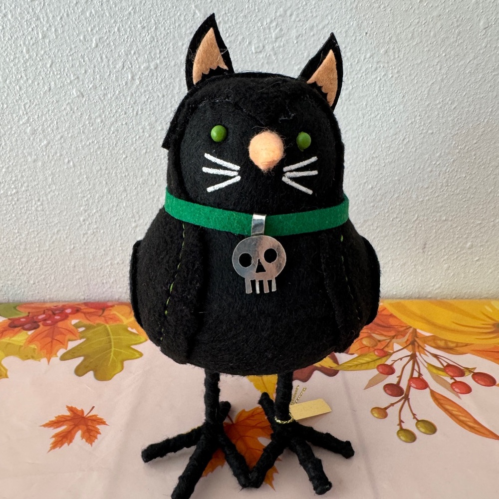Featherly Friend cat wearing a skull pendant New